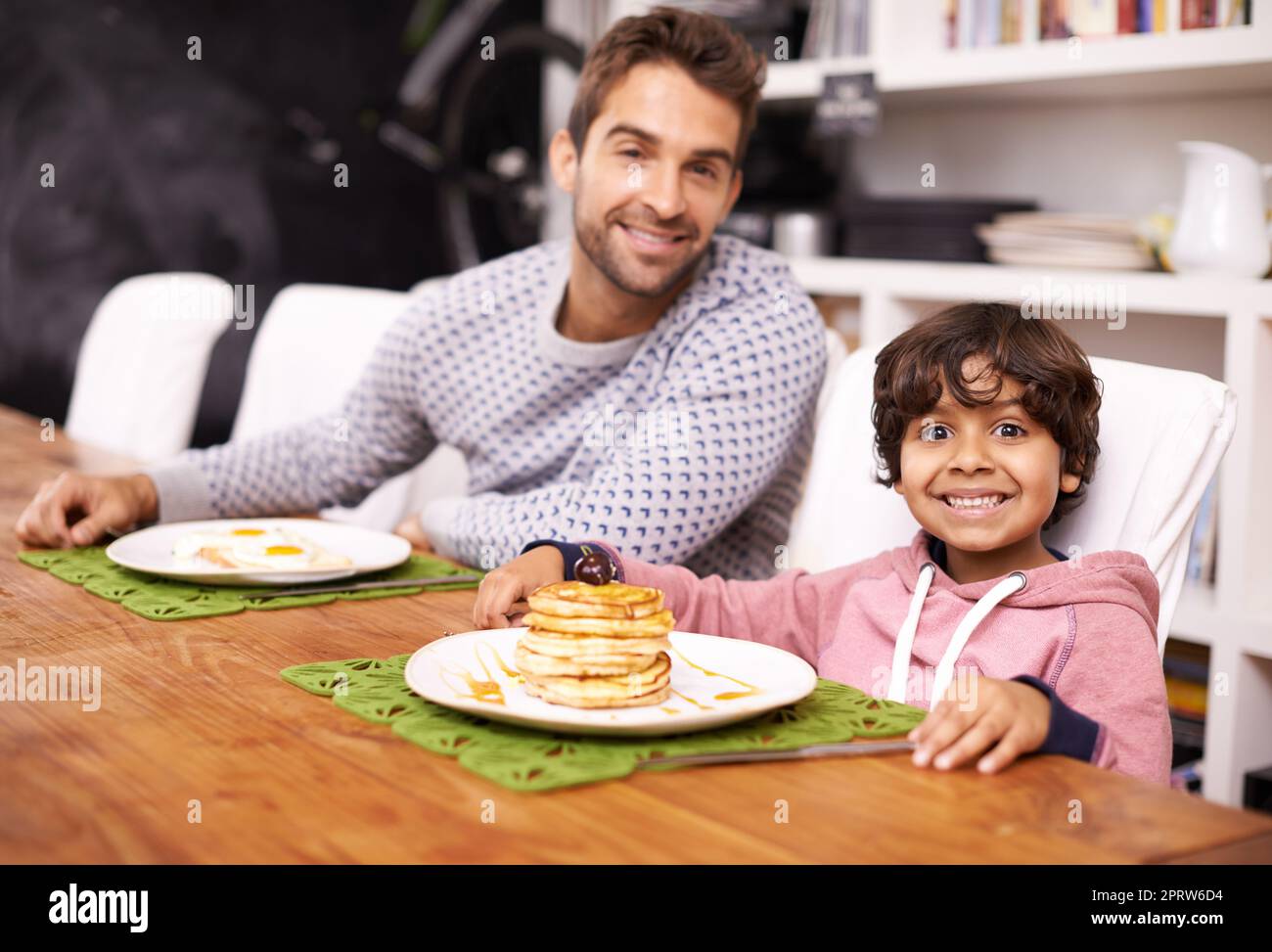 Dafdisten macht die besten Flapjacks. Porträt eines Jungen, der beim Frühstück mit seinem Vater sitzt. Stockfoto