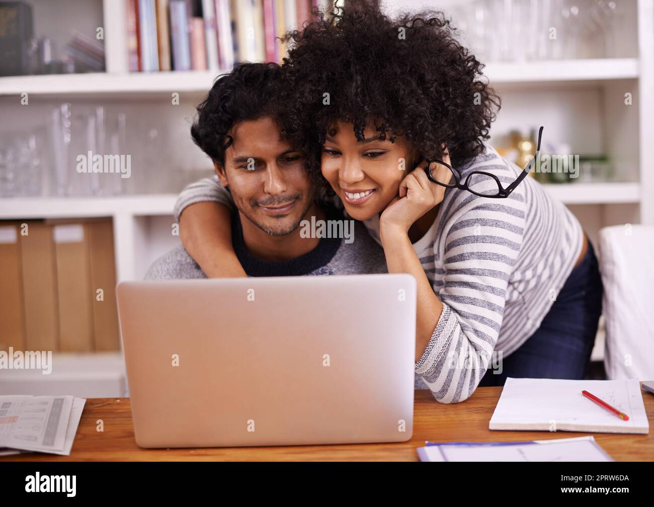 Surfen und Kleben. Ein junges Paar, das zu Hause einen Laptop benutzt. Stockfoto