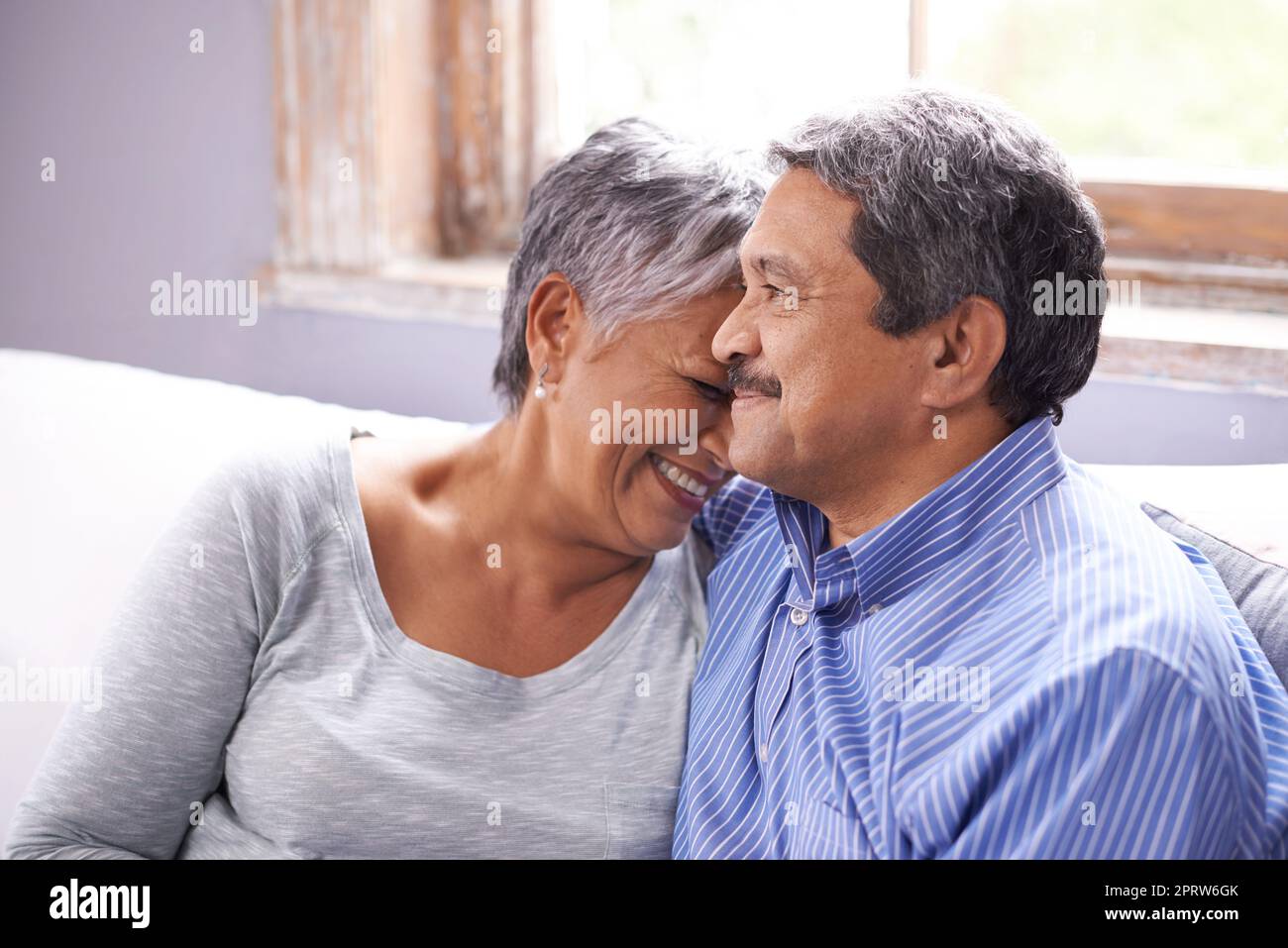 Genießen ihre goldenen Jahre zusammen. Ein liebevolles reifes Paar sitzt auf ihrem Sofa. Stockfoto