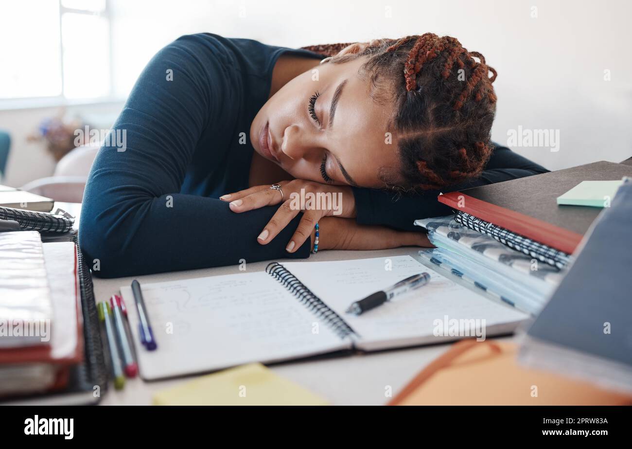 Burn-out, schlafender Student am Schreibtisch mit Büchern, während er im Zimmer studiert, lernt oder studiert. Müde Müdigkeit gen z schwarze Frau im Heimbüro mit Notebook für Stipendien Stockfoto