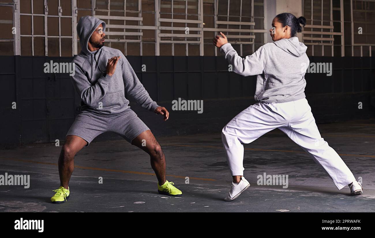 Die wahren Straßenkämpfer. Ein junger Mann und eine junge Frau üben gemeinsam die Kampfkunst. Stockfoto