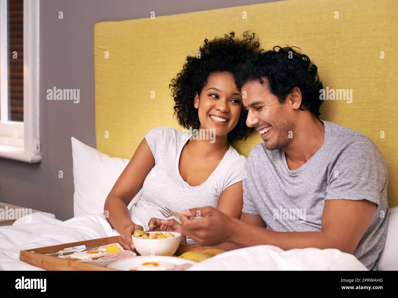 Genießen Sie das Frühstück im Bett. Ein süßes Paar, das sich das Frühstück im Bett teilt. Stockfoto