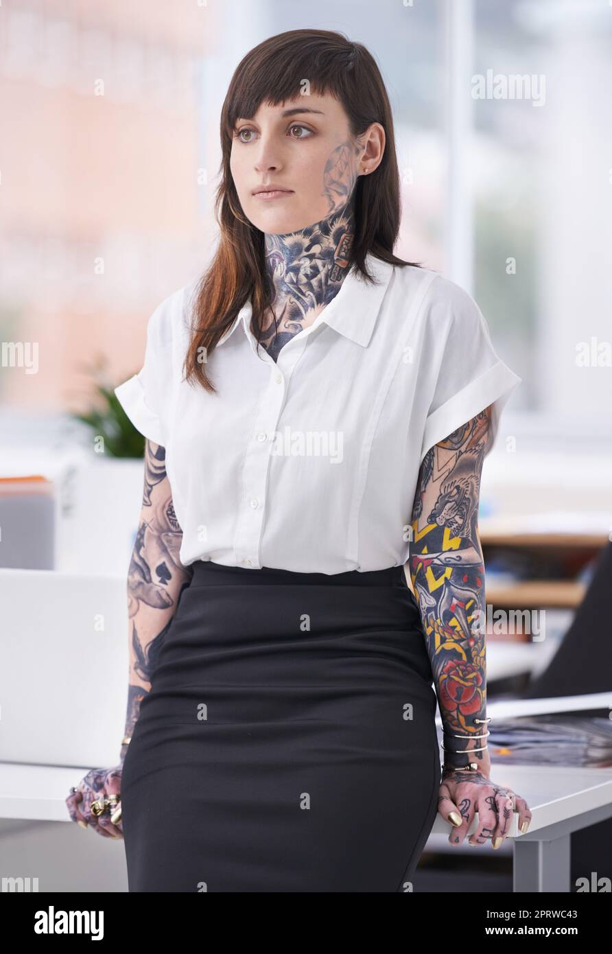 Shes bereit, die Unternehmensszene zu rocken. Eine mit Tätowierungen bedeckte junge Geschäftsfrau in ihrem Büro. Stockfoto