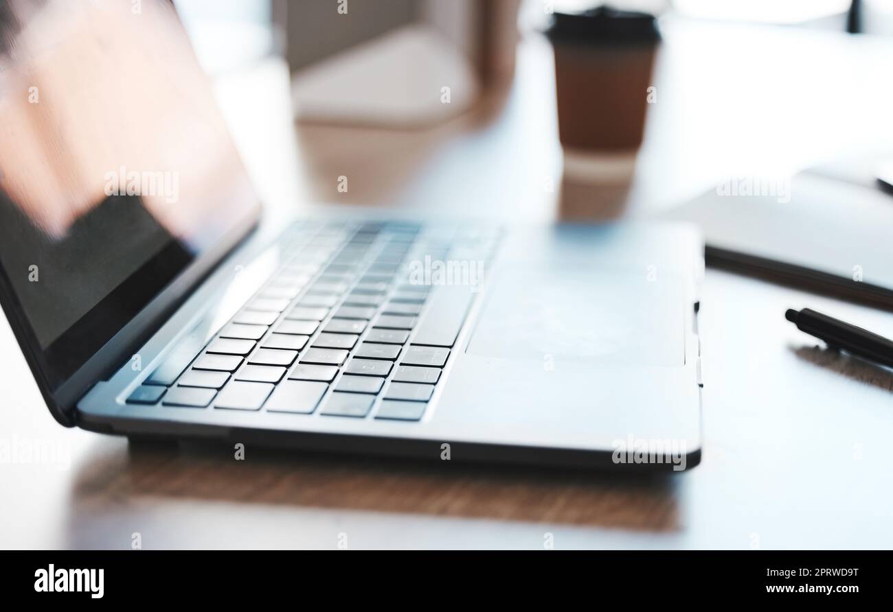 Laptop, Computer und Schreibtisch mit einem Notebook auf einem Tisch in einem leeren Büro bei der Arbeit. Technologie, E-Mail und Konnektivität mit einem drahtlosen Gerät an einer Workstation für Marketing, Werbung oder Design Stockfoto
