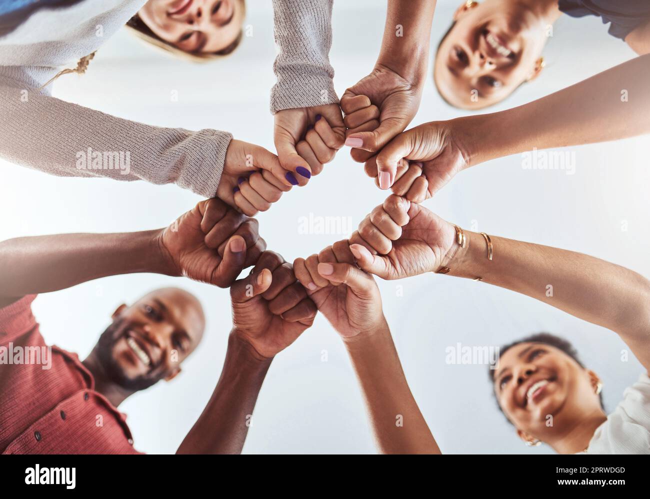 Teamwork, Einheit und Hände oder Faust für Unterstützung, Vertrauen und Gemeinschaft unter blauem Himmel. In der Gruppe „Diversity“ stehen Männer und Frauen zusammen, um Teamarbeit, Zusammenarbeit und Hilfe beim Teamaufbau zu leisten Stockfoto