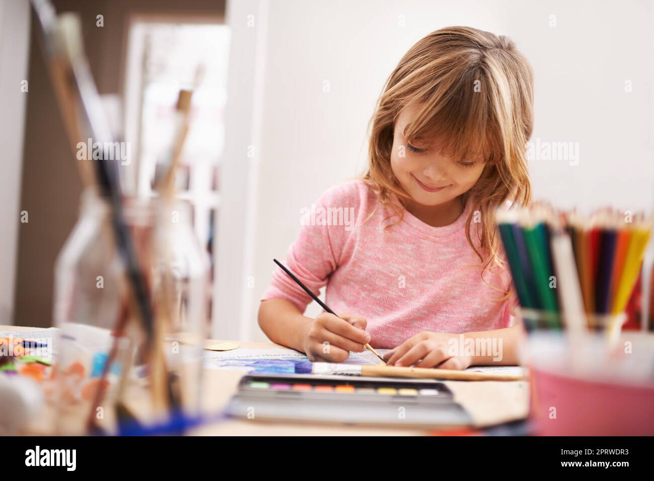 Sie liebt ihre Malerei. Ein kleines Mädchen, das ein Bild malt. Stockfoto