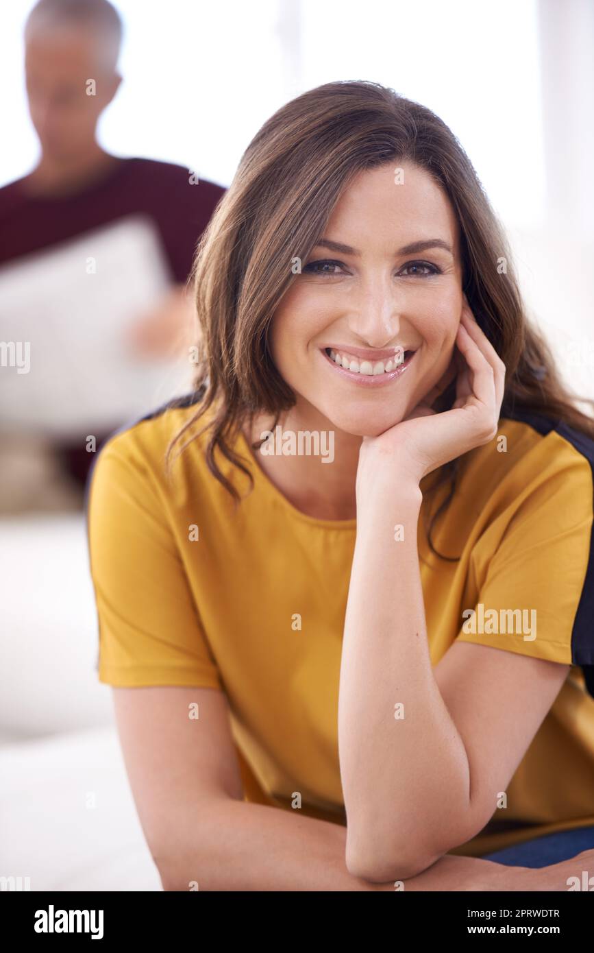 Der Tag beginnt genau richtig. Eine lächelnde junge Frau und ihr reifer Mann lesen zu Hause die Zeitung. Stockfoto