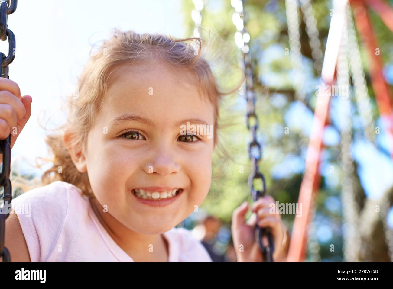 Ich möchte höher gehen. Porträt eines süßen kleinen Mädchens, das auf einem Swingset spielt. Stockfoto