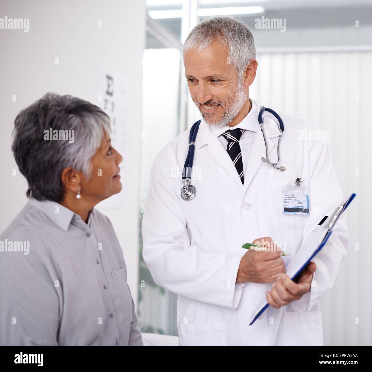 Eine perfekte Gesundheitsvorsorge. Ein glücklicher Arzt, der sich um einen seiner reifen Patienten gefreut hat. Stockfoto