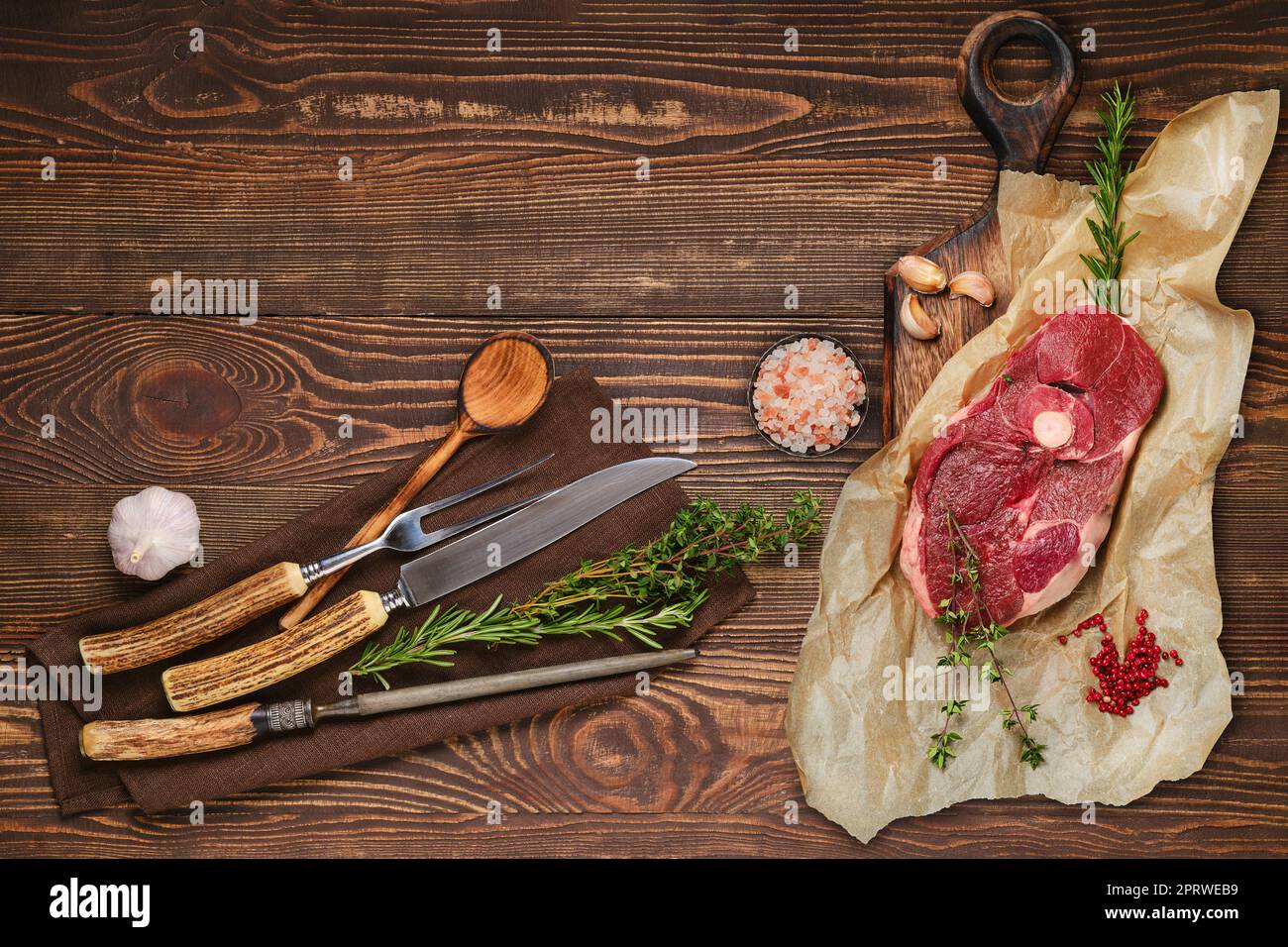 Rohes, in der Mitte geschnittenes Steak mit Gabel, Messer und Spitzer auf Serviette Stockfoto