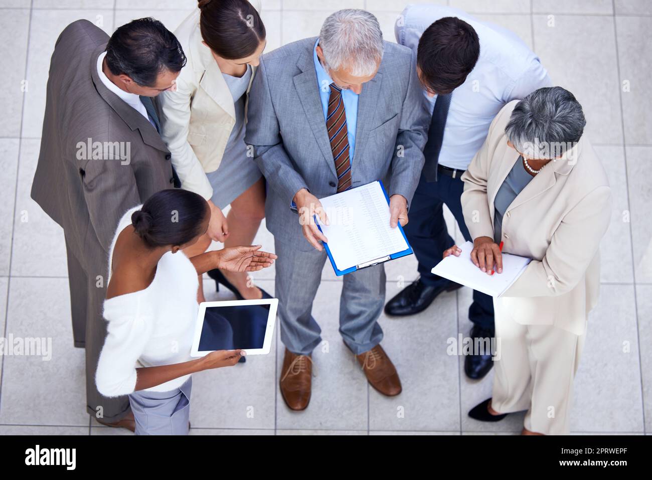 Sie haben ein spontanes Meeting. Ein vielfältiges Business-Team diskutiert Schreibarbeit in einem Meeting. Stockfoto