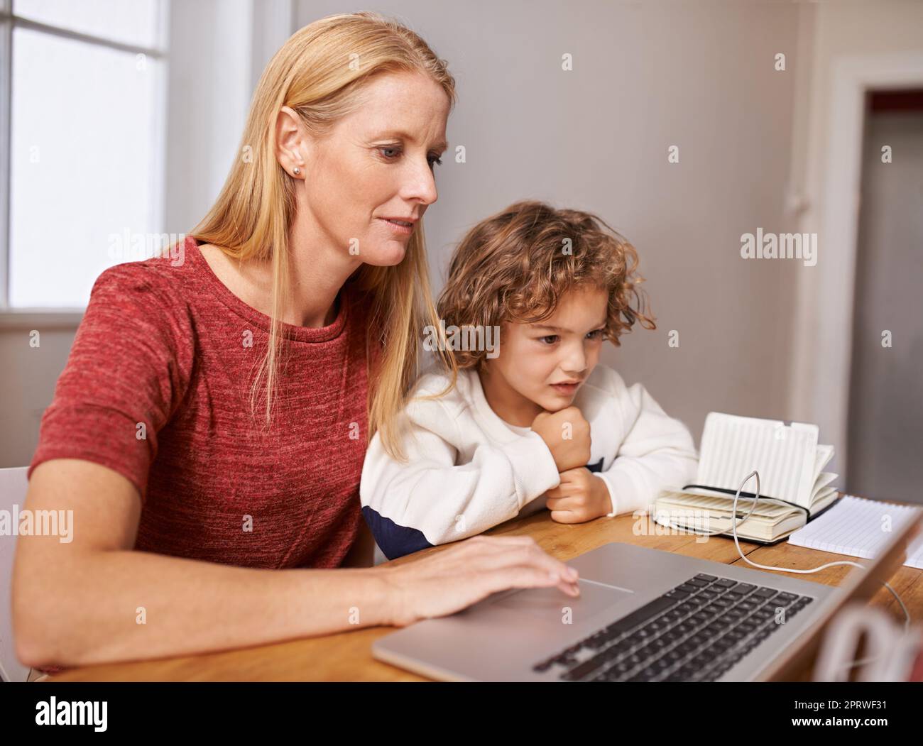 Lernen über neue Dinge mit dem Laptop. Eine Mutter und ihr Sohn betrachten etwas auf einem Laptop-Bildschirm. Stockfoto