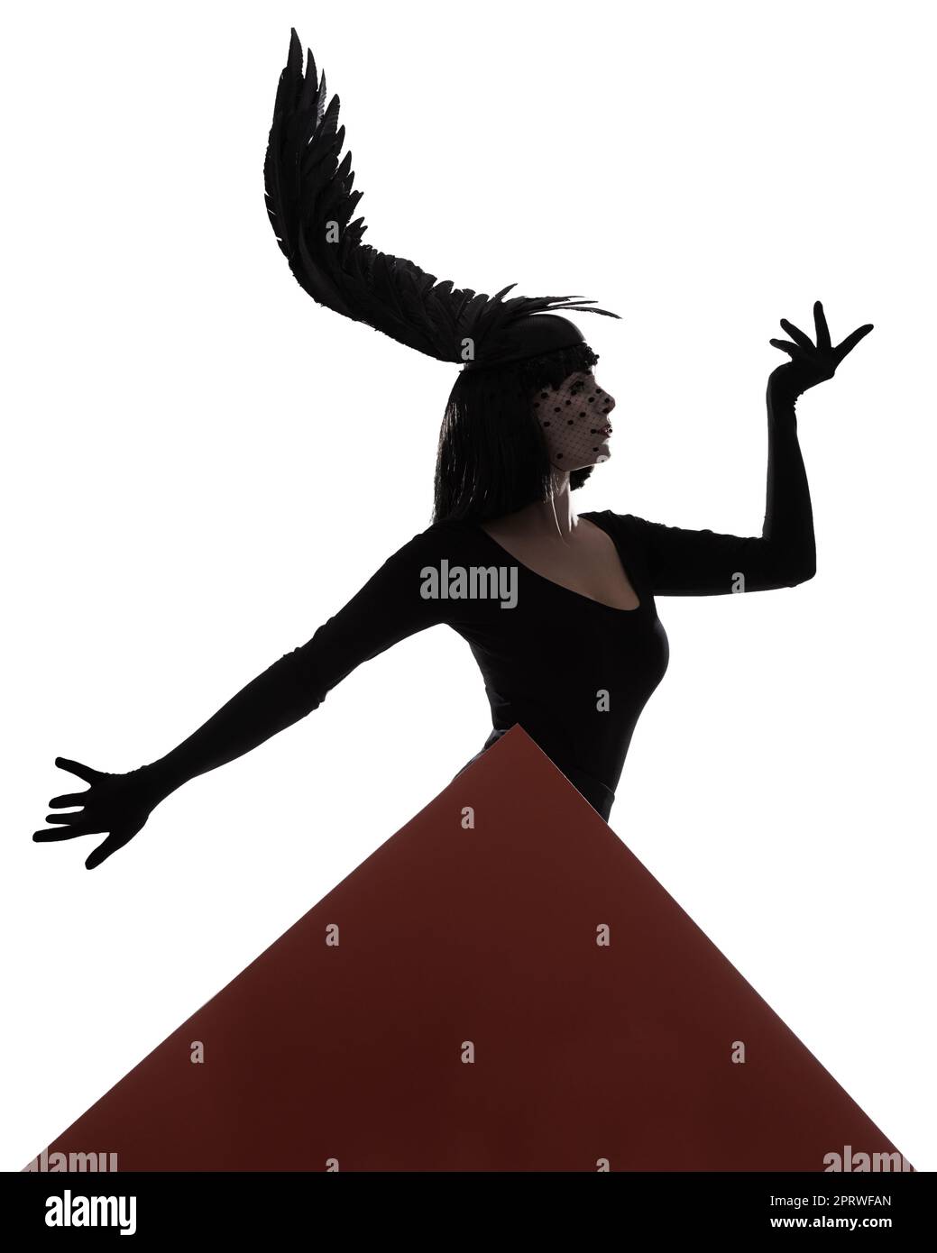 Die Geometrie der Kunst. Eine junge Frau mit einem flügelförmigen, gefiederten Kopfteil mit roter Dreiecksgrafik. Stockfoto