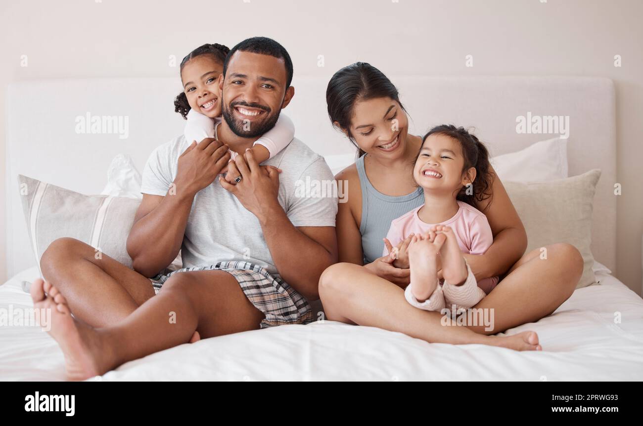 Porträt, glücklich und Familie im Bett mit Lächeln, Umarmungen und Liebe, während Sie sich am Morgen entspannen. Eltern, die sich mit ihren Kindern im Schlafzimmer verbinden, mit Glück, Fürsorge und gesunder Beziehung zu Hause Stockfoto