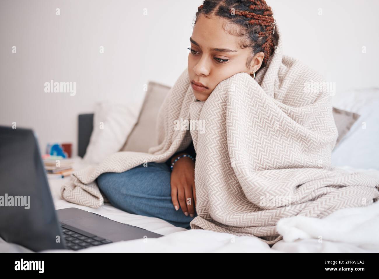 Depression, Bett und Frau streamen auf einem Laptop, sehen traurig und einsam aus, während sie auf der Suche nach Online-Komfort im Schlafzimmer sind. Psychische Gesundheit, Angst und Schlaflosigkeit durch ein gelangweiltes schwarzes Mädchen, das sich zu Hause einen Film ansieht Stockfoto