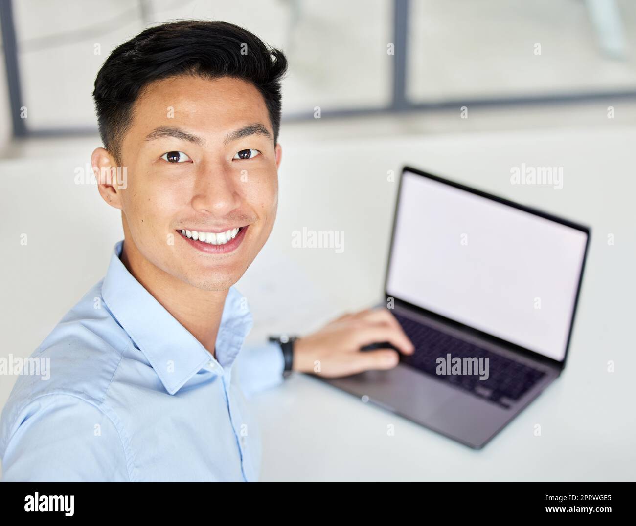 Laptop, glücklicher Geschäftsmann, der ein Selfie im Büro macht und eine E-Mail mit Mockup-Bereich am Schreibtisch schreibt. Lächeln, Freude und asiatischer Arbeiter sind stolz darauf, dass sie ein Bild online in sozialen Netzwerken teilen Stockfoto