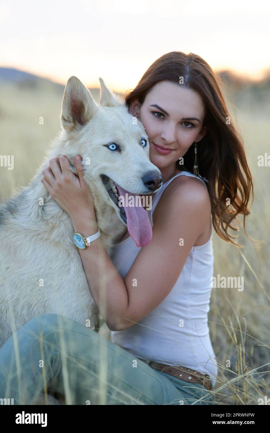 Er bringt mich immer zum Lächeln. Porträt einer attraktiven jungen Frau, die sich mit ihrem Hund draußen anfreundet Stockfoto