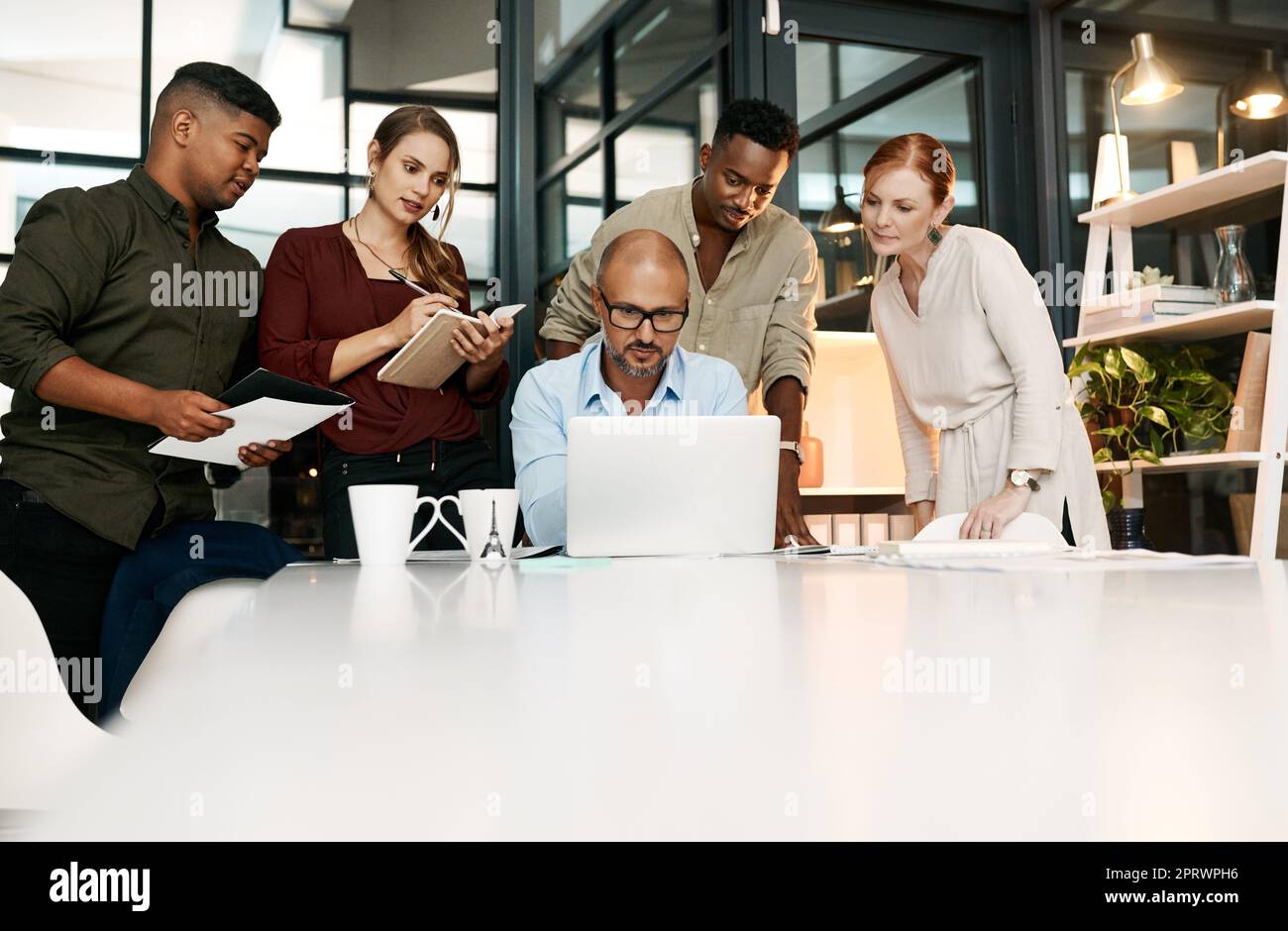 Eine effektive Strategieentwicklung nimmt dem Wachstum des Unternehmens das Rätselraten ab. Eine Gruppe von Geschäftsleuten, die während eines Meetings in einem modernen Büro einen Laptop verwenden. Stockfoto