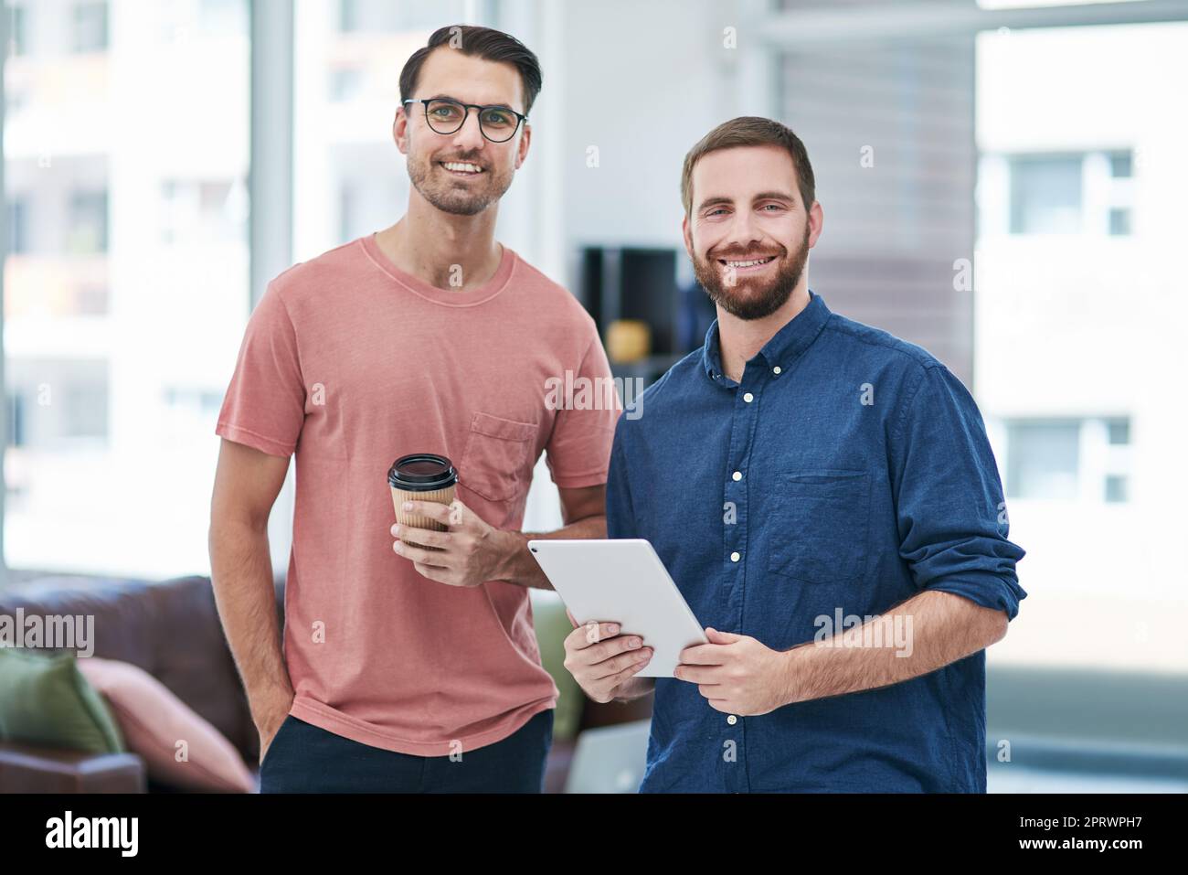 Wir bringen nichts als Authentizität in unsere Marke. Zwei junge Geschäftsleute nutzen ein digitales Tablet in einem modernen Büro. Stockfoto