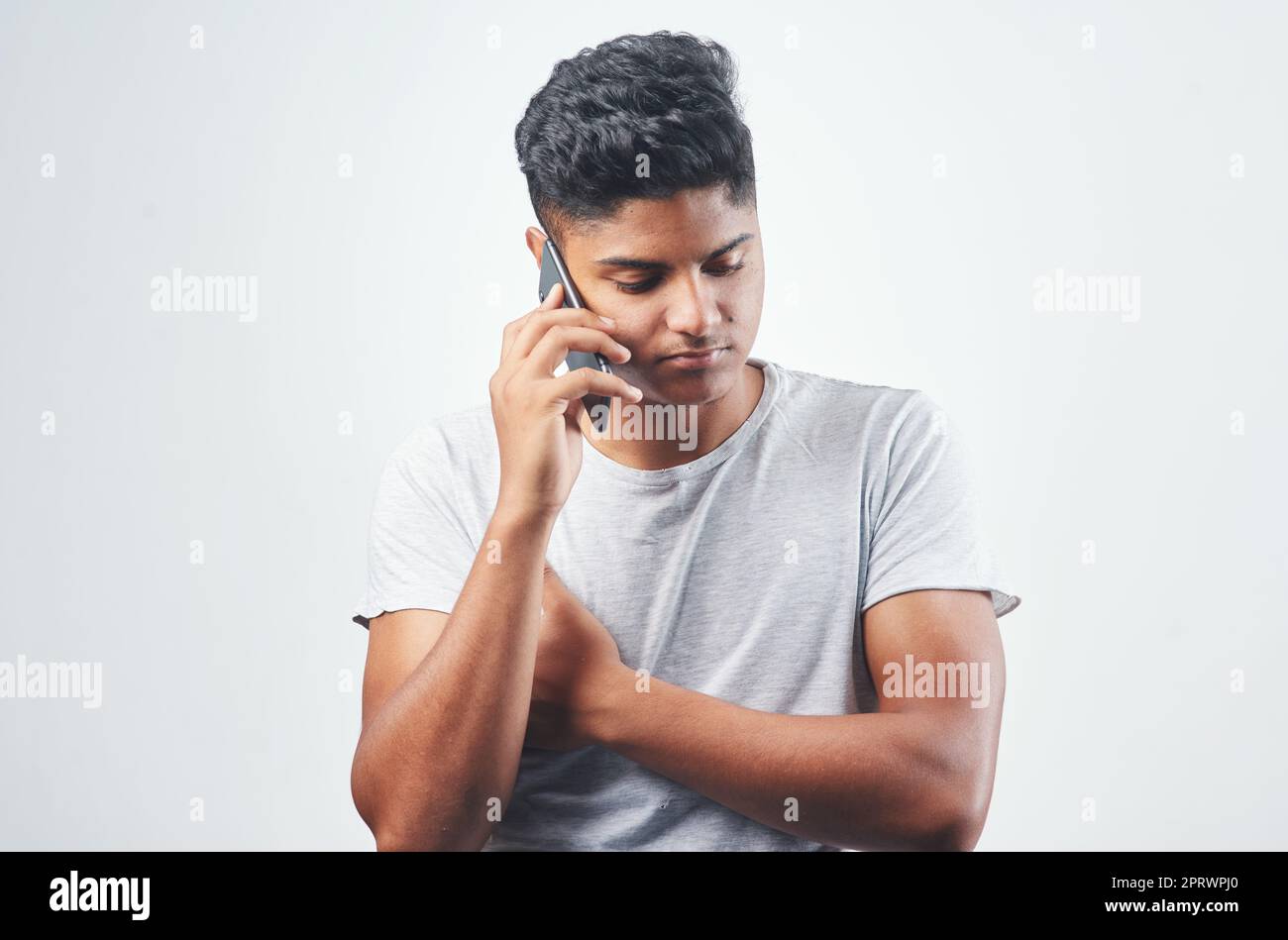 Shes nimmt meine Anrufe immer noch nicht an. Studioaufnahme eines jungen Mannes, der auf seinem Handy spricht, während er vor einem weißen Hintergrund steht. Stockfoto