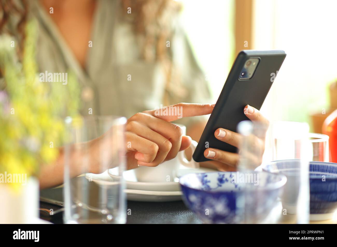 Frau Hand mit Smartphone an einem Restauranttisch Stockfoto