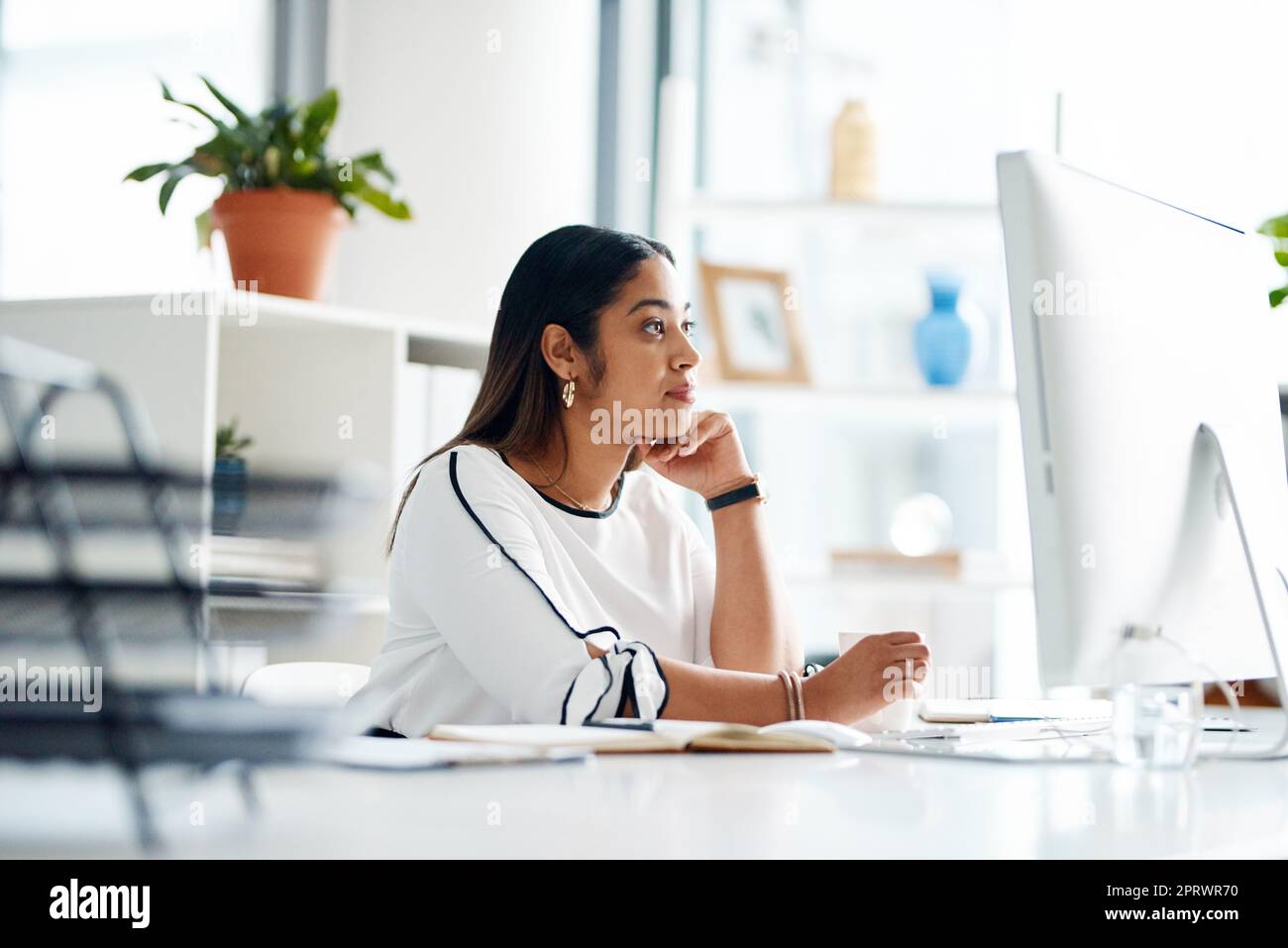 Ihre Ziele mit Hingabe verfolgen. Eine junge Geschäftsfrau, die in einem Büro an einem Computer arbeitet. Stockfoto