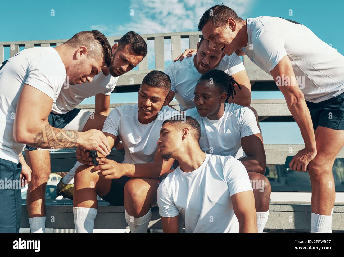 Schauen Sie sich all unsere Unterstützer an, die uns gute Wünsche senden. Ein Rugby-Spieler zeigt seinen Teamkollegen etwas auf seinem Handy. Stockfoto