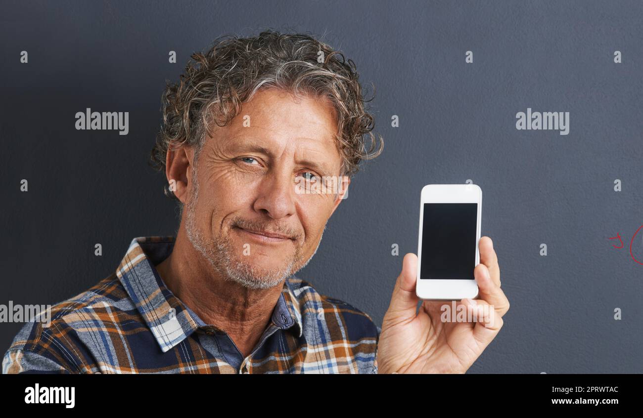 Mein handlicher persönlicher Assistent. Ein Porträt eines glücklichen, reifen Mannes, der sein neues Smartphone zeigt. Stockfoto