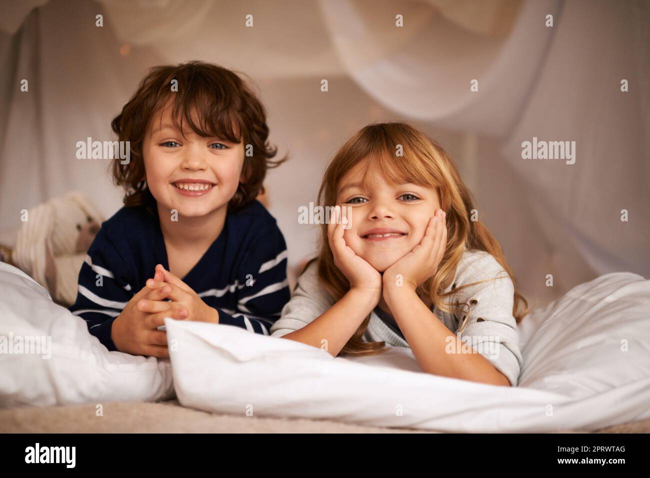 Weil ich einen Bruder habe, habe ich immer einen besten Freund. Porträt zweier entzückender Geschwister, die auf ihrem Bett liegen. Stockfoto