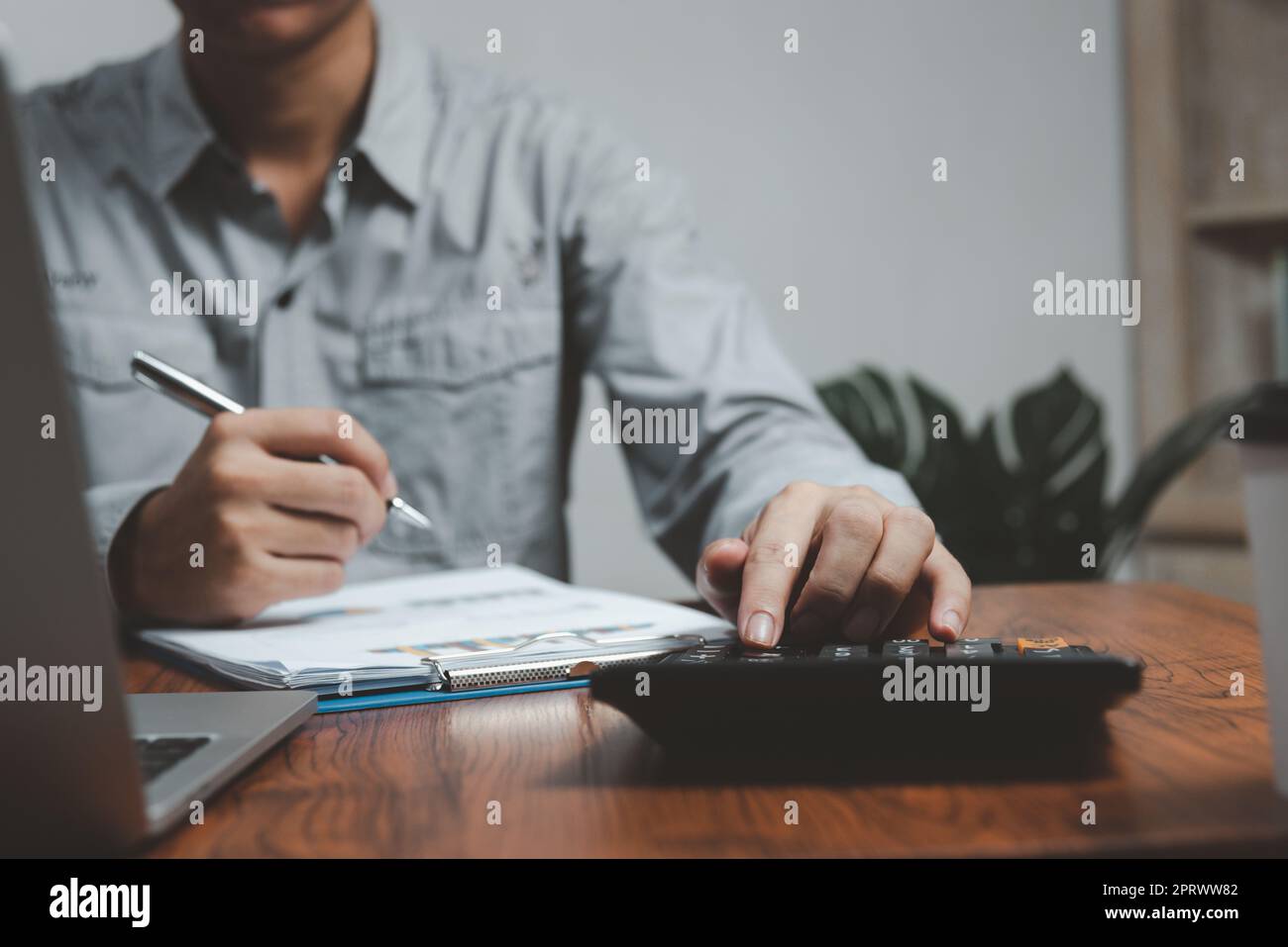 Grafik: Geschäfts- und Marketingwachstum bei Finanzdokumenten. Geschäftsmann oder Buchhalter, der am Taschenrechner arbeitet. Investitionsbuchhaltung, Wirtschaft, kommerzielles Konzept. Stockfoto