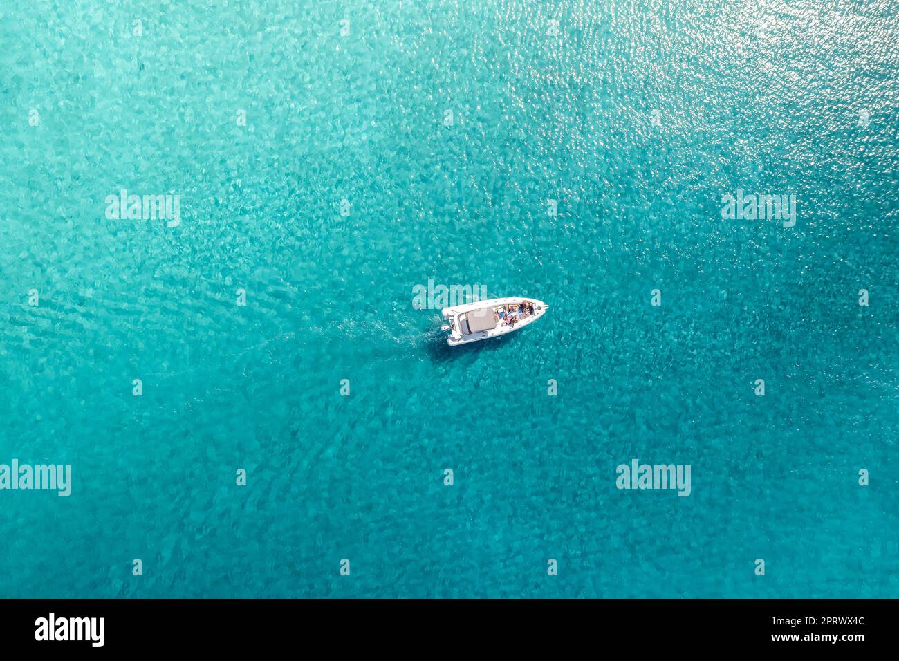 Ansicht des Motorbots von oben mit Touristen in einem türkisfarbenen Meer Stockfoto