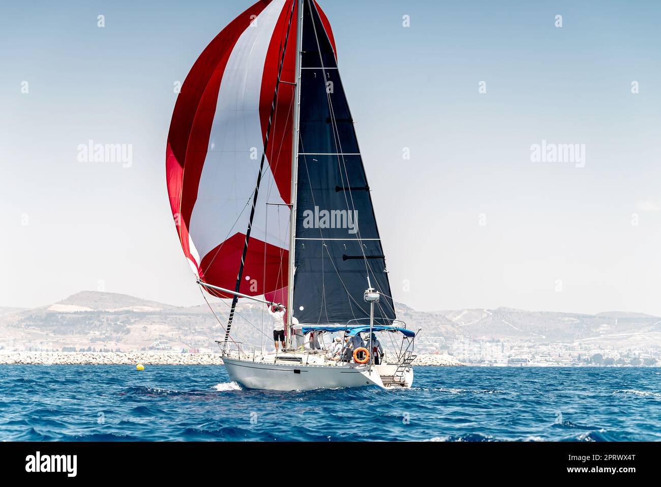 Segelboot auf einem ruhigen Wasser mit rotem Segel während der Regatta Stockfoto