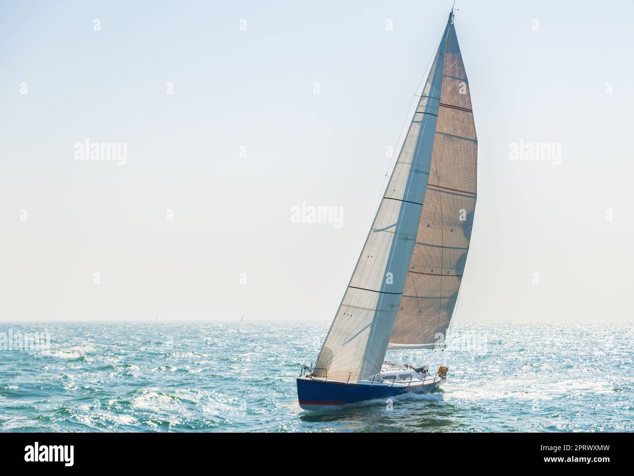 Sportsegler auf dem offenen Meer gegen das Licht Stockfoto