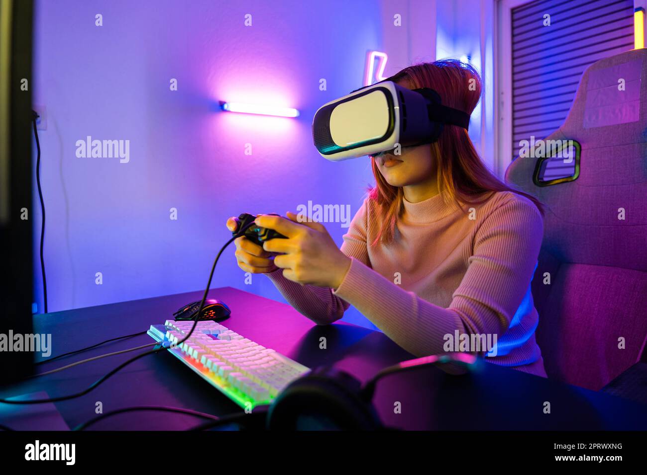 Gamer in VR-Headset-Brillen erkunden Metaverse spielen Videospiel online mit Joystick Stockfoto