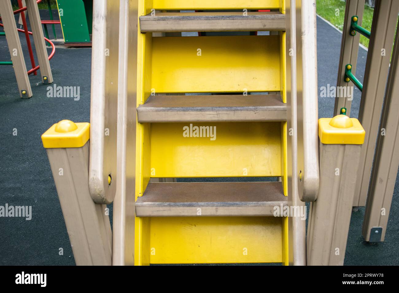 Nahaufnahme von Holztreppen auf einer leeren gelben Treppe auf einem Spielplatz im Freien, einem sicheren Spielplatz für Kinder Stockfoto