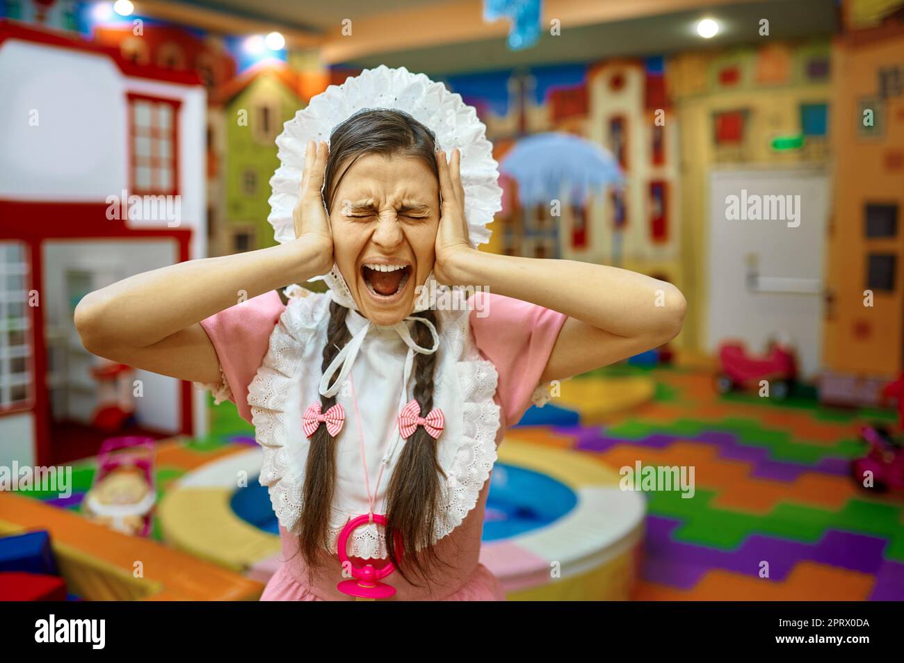 Porträt von lustigen Frau wie Neugeborenen Baby Grimacing Stockfoto