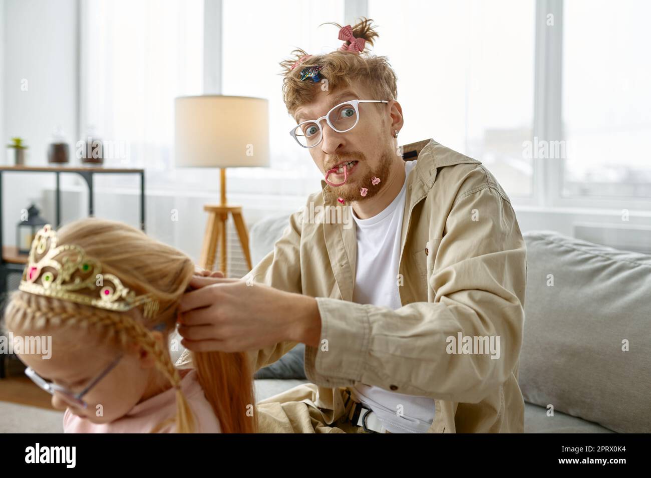 Vater mit verrückter Frisur macht Haare für Tochter Stockfoto