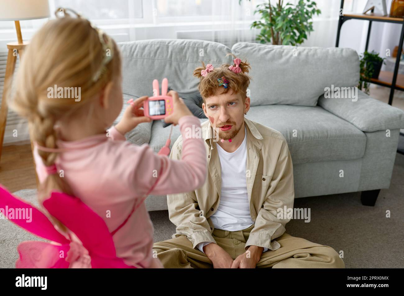 Tochter macht Foto von Vater mit lustigen Make-up Stockfoto
