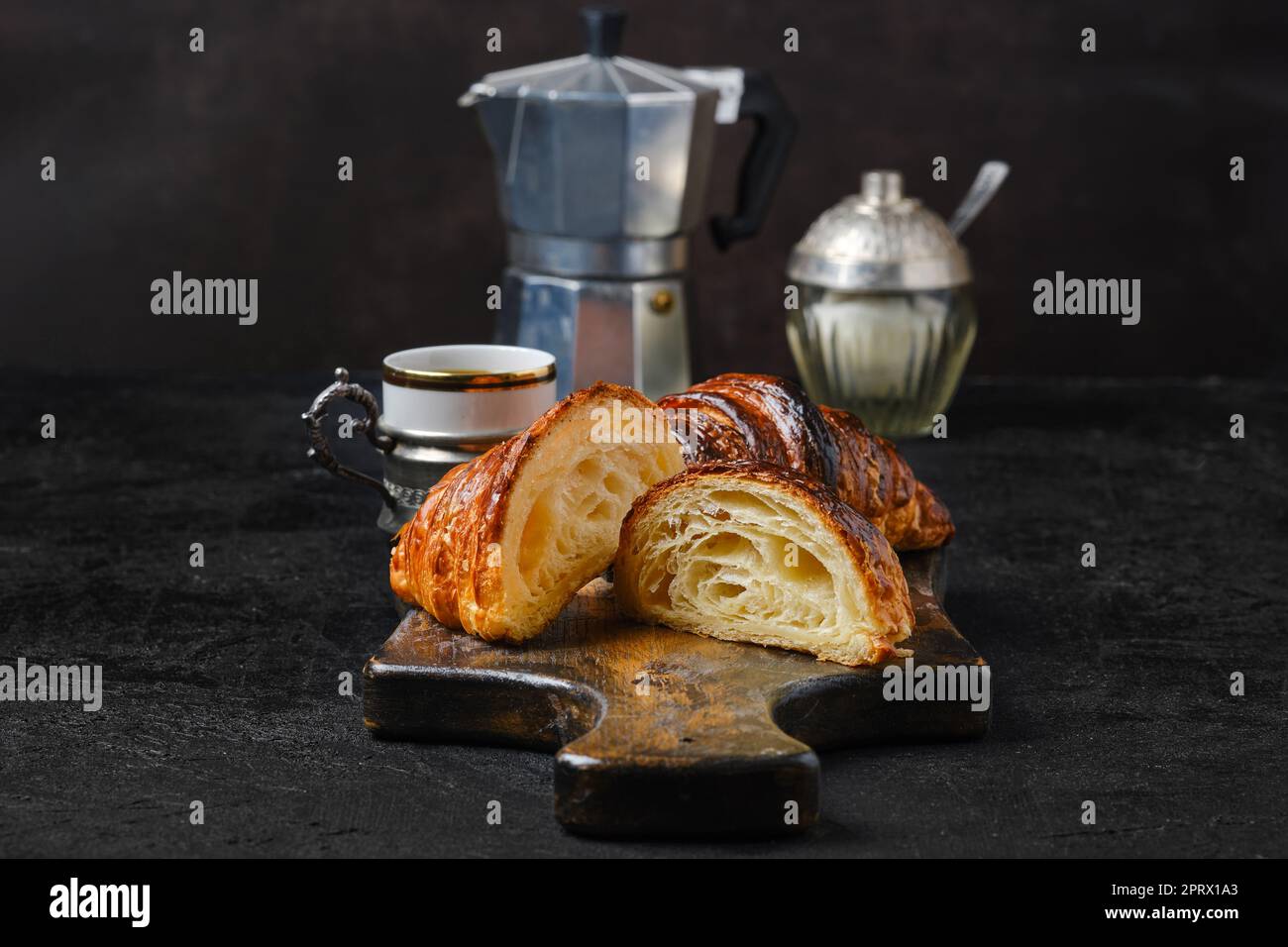 Klassisches Frühstück mit halbgeschnittenen Croissants und Kaffee Stockfoto