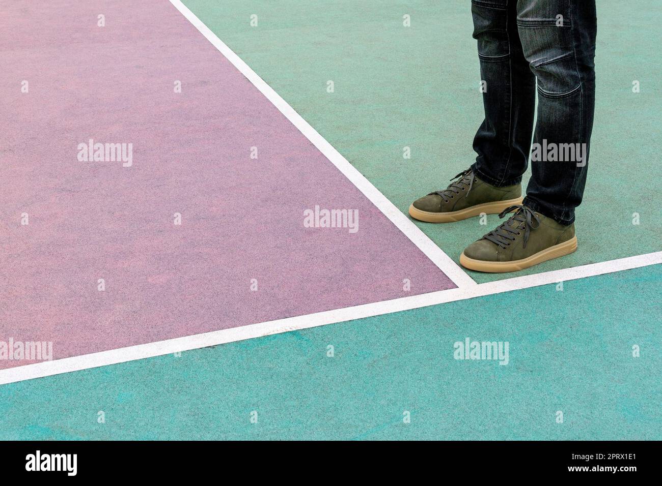 Männer Füße stehen auf dem gummierten Sportplatz, der in Pastelltönen gestrichen ist Stockfoto