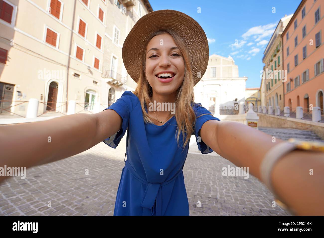 Lächelndes Mädchen in blauem Kleid und Hut macht Selfie-Bilder in Anconara, Marken, Italien Stockfoto