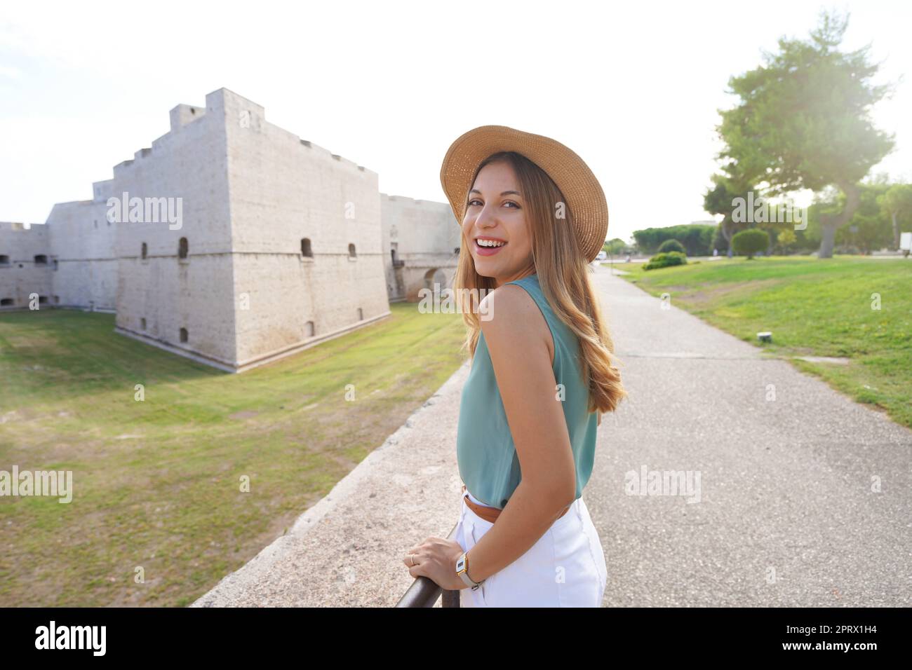 Kulturtourismus in Apulien, Italien. Porträt einer schönen jungen Frau mit Schloss Barletta im Hintergrund, Apulien, Italien. Stockfoto