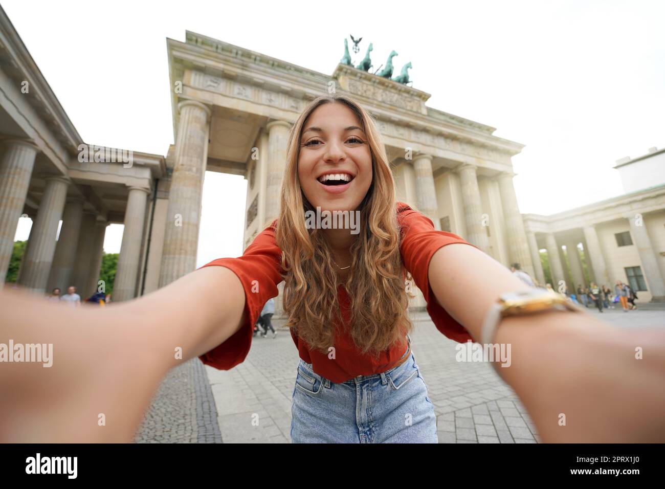 Reisen Sie in Berlin. Glückliche Touristin macht Selfie-Foto mit Smartphone-Kamera vor dem Brandenburger Tor in Berlin. Selbstporträt eines schönen Schulaustauschmädchens, das Europa besucht. Stockfoto