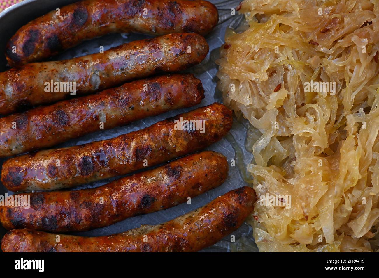 Schließen gegrillten Nürnberger Bratwürste mit Sauerkraut Stockfoto