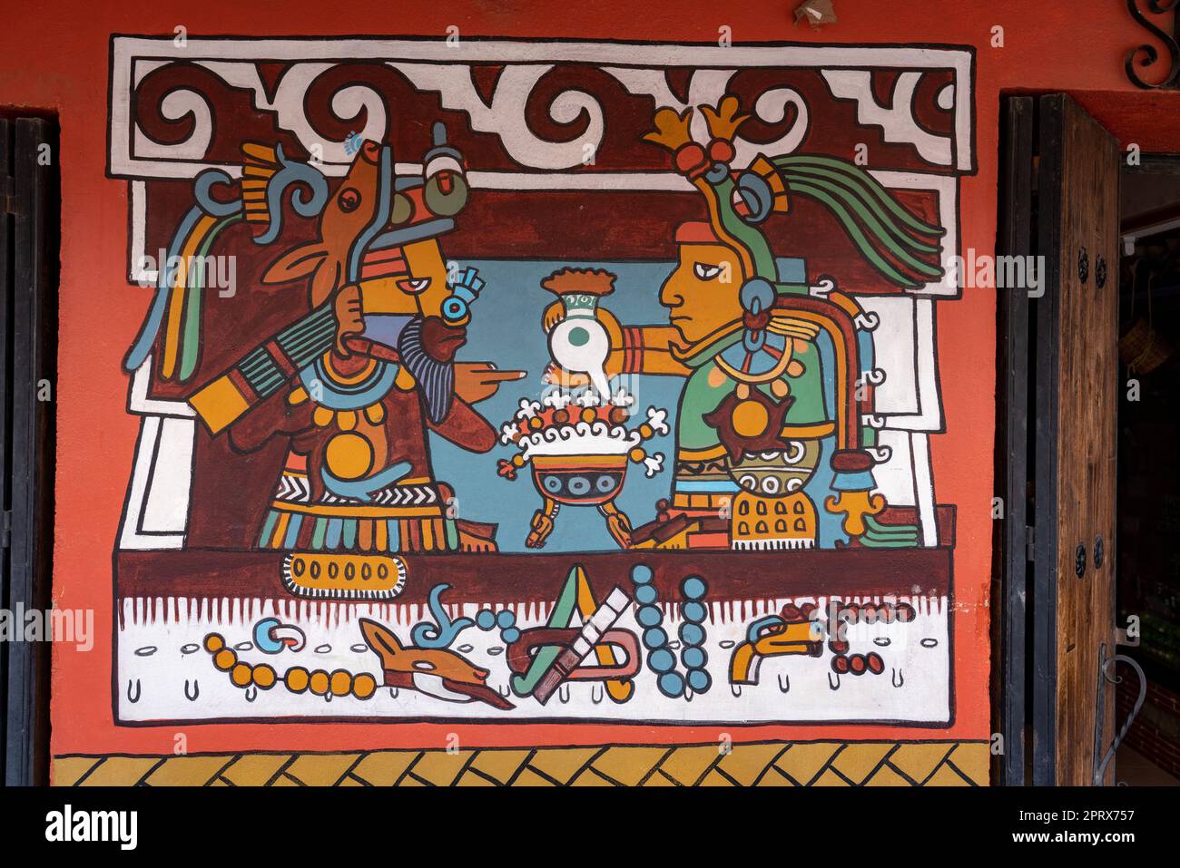 Gemalte Wandbilder, auf denen prähispanische Zapoteken Amerikaner zeigen, die Kakao zum Trinken zubereiten. Tlacolula de Matamoros, Mexiko. Das Schild war an der Wand eines Busins Stockfoto