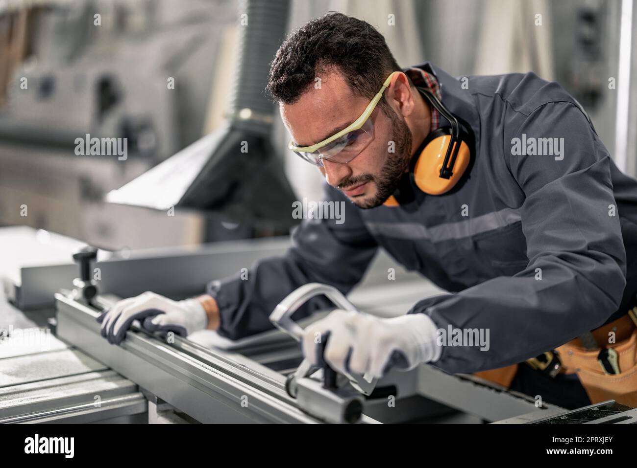 Holzwender messen und berechnen die richtige Größe des Werkstücks mit Hand- und Elektrowerkzeugen. Schneiden, Formen, Drehen, Glätten und Ausbalancieren von Holzbefestigungen Stockfoto