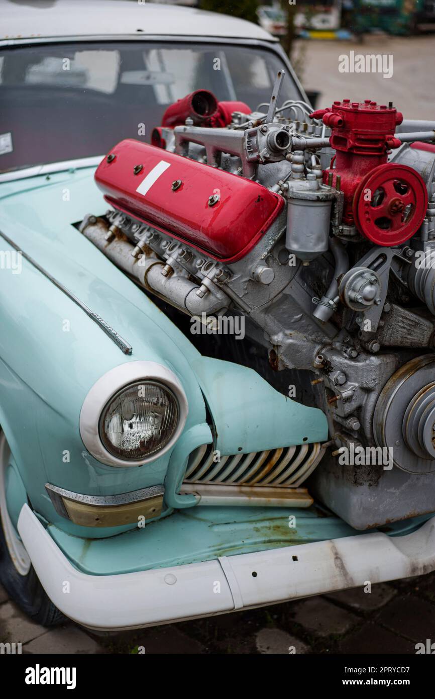 Bild eines getunten Oldtimers mit einem großen Motor, der aus der Motorhaube ragt. Stockfoto