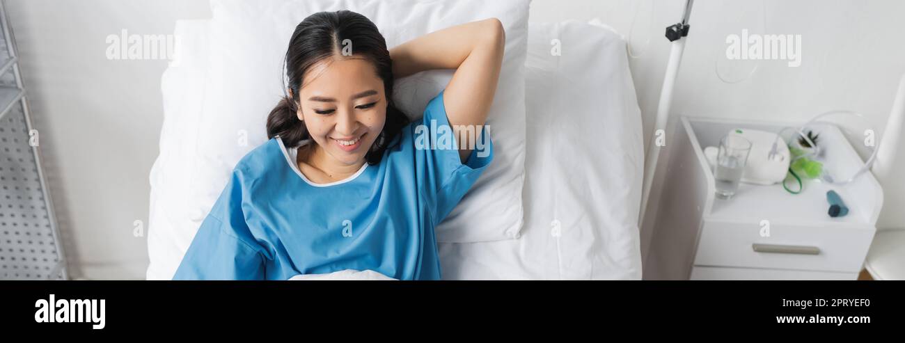 Junge asiatische Frau im Krankenhaus Kleid lächelnd im Bett, Banner, Stock Bild Stockfoto