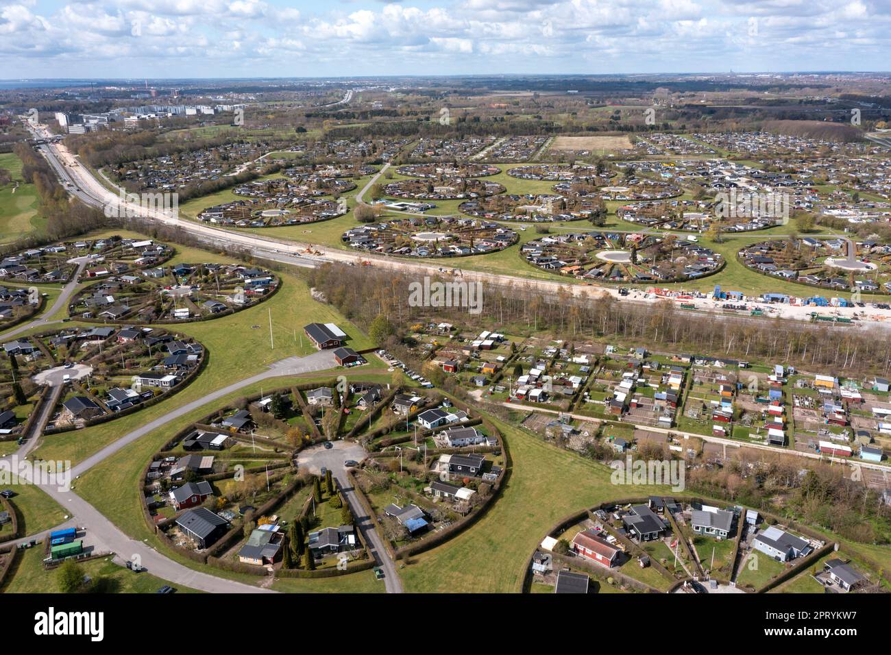 Brondby, Dänemark. 27. April 2023. Aus der Luft sieht die dänische Gartenstadt Brondby Haveby in der Nähe von Kopenhagen aus wie die Kulisse eines Science-Fiction-Films. Die 24 kreisförmigen Gemeindegärten wurden in den 1960er Jahren nach einem Design des Landschaftsarchitekten Mygind angelegt. Sie ähneln alten dänischen Dörfern, in denen sich die Bewohner in dem Dorf gut im Zentrum trafen, um Neuigkeiten auszutauschen. (Mit einer Drohne erschossen). Kredit: Stephan Schulz/dpa-Zentralbild/dpa/Alamy Live News Stockfoto