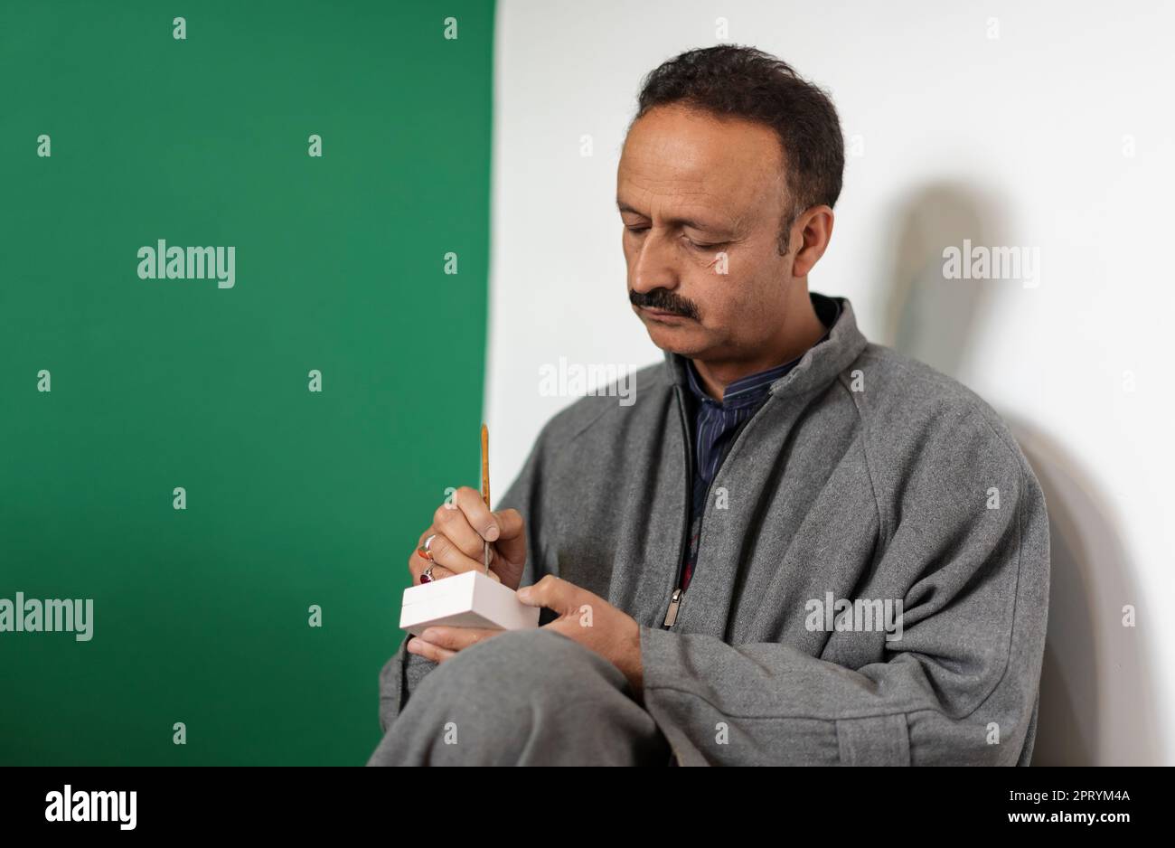 Maqbool Jan, ein preisgekrönter Handwerker, wird in seiner Werkstatt in Srinagar gesehen, wie er mit Paper Mache einen Artikel entwirft. Papier-Mache Handwerk, ist ein uraltes Handwerk, das von mir Sayyid Ali Hamadani, der im 14. Jahrhundert mit qualifizierten Handwerkern aus Persien kam, in das Kaschmirtal eingeführt wurde. Papier-Mache ist ein französisches Wort, das kautes Papier bedeutet und dessen Herstellung zwei Schritte umfasst: Sakhtsazi und Naqashi. Sakhtasazi, die erste Phase der Vorbereitung, umfasst die Herstellung der Figur aus einer Mischung aus Papierhalbstoff mit Hilfe von Reistroh und Kupfersulfat. Im letzten Schritt Stockfoto